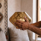 The maker's hands presenting the Nouara lantern, petals open