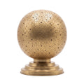 Ourika pierced brass globe table lamp on a white studio background