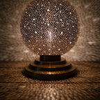 Detail of the lit Ourika globe, warm light through hand-perforated brass