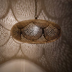 Close view of the Saada pendant lit, small openings glowing