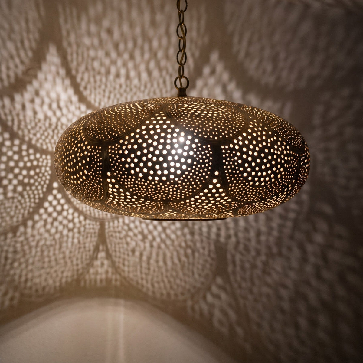 Close view of the Saada pendant lit, small openings glowing