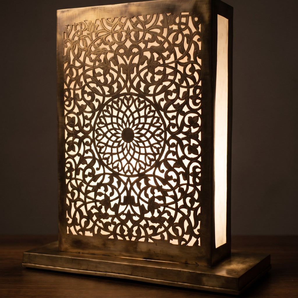 Close view of the lit Sabah lamp, a warm glow at the base of the engraved brass disc