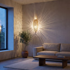 Sana brass sconce lit on a modern bedroom wall