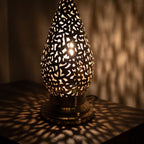 Close view of a lit Shama lantern, light passing through engraved calligraphy