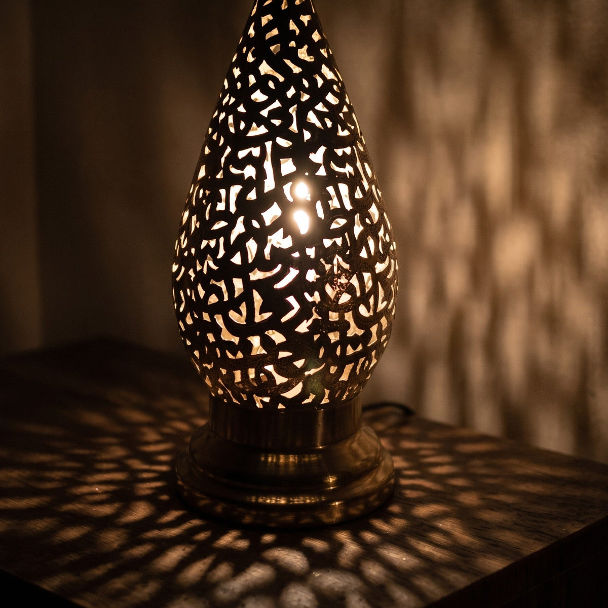 Close view of a lit Shama lantern, light passing through engraved calligraphy
