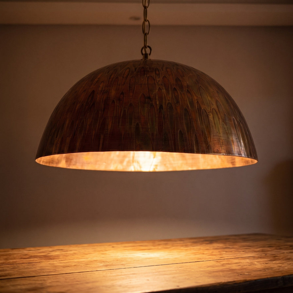 Close view of the lit Siniya pendant, engraving catching warm light at the copper rim