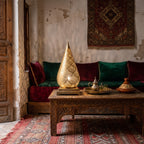 Siraj lantern lit at dusk on the floor of a Moroccan riad courtyard