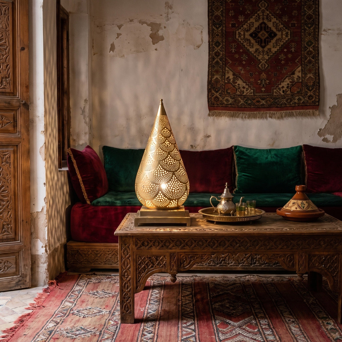 Siraj lantern lit at dusk on the floor of a Moroccan riad courtyard