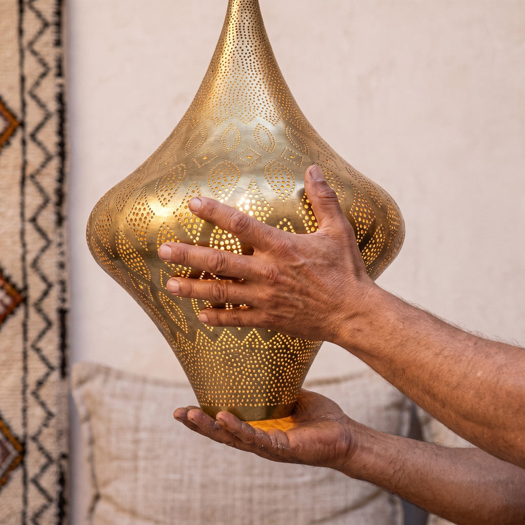Maker's hands holding the Skoura teardrop lantern