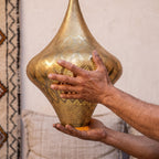 Maker's hands holding the Skoura teardrop lantern