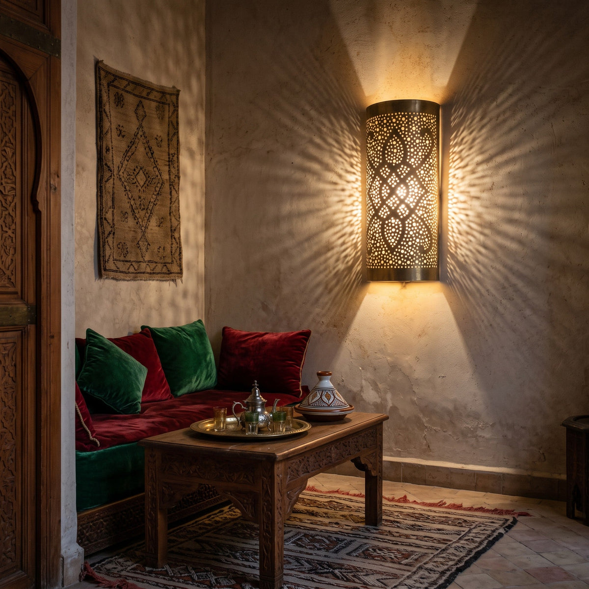 Two Sqala sconces lit on a stone-toned wall in a Moroccan riad