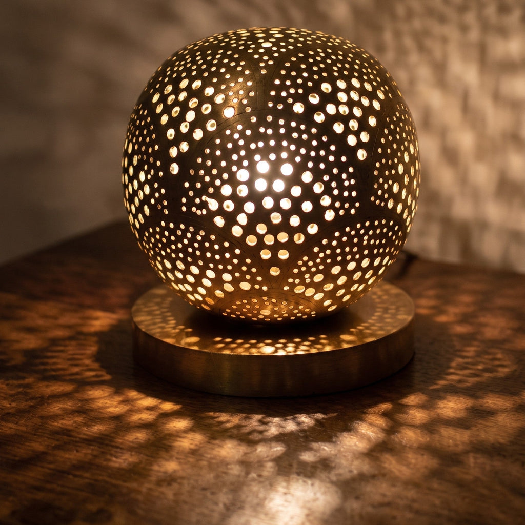Detail of the lit Tala lamp, points of light through the hand-pierced brass