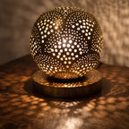 Detail of the lit Tala lamp, points of light through the hand-pierced brass