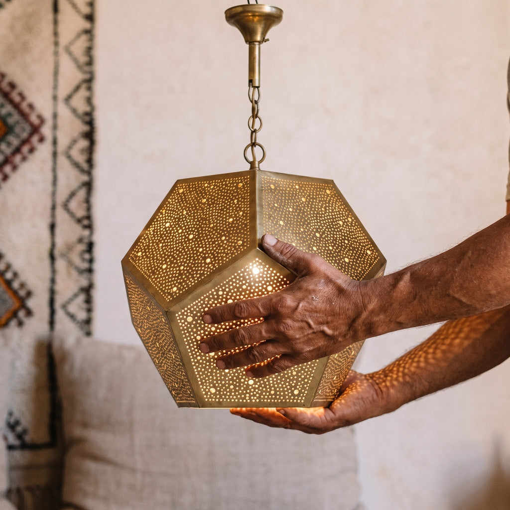 Maker's hands holding the faceted Thouraya shade