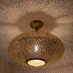 Detail of the lit Warda pendant, light through the pierced pattern