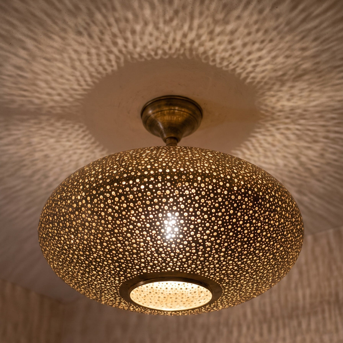 Detail of the lit Warda pendant, light through the pierced pattern