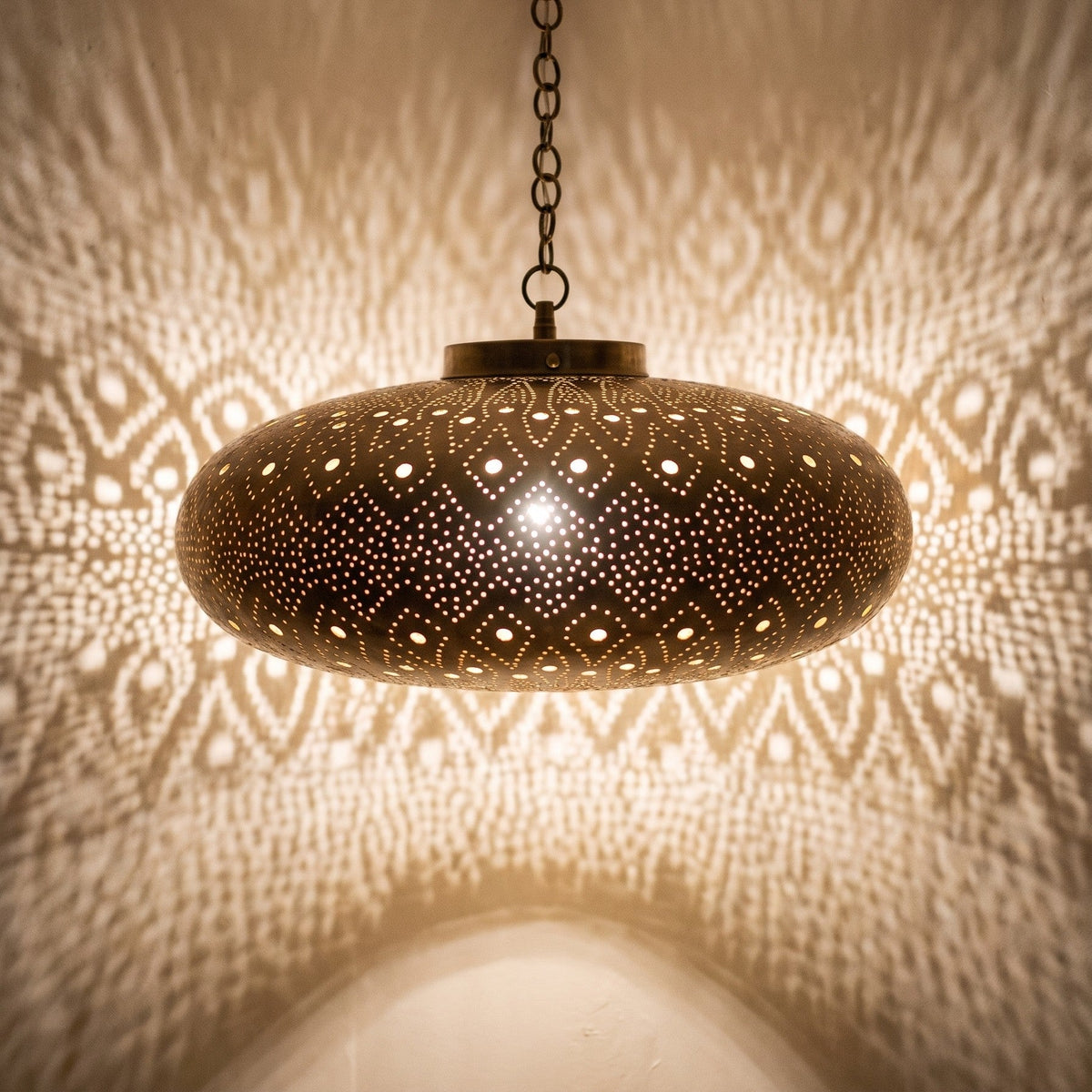 Close view of the lit Yakout pendant, light coming through the pierced leaf pattern
