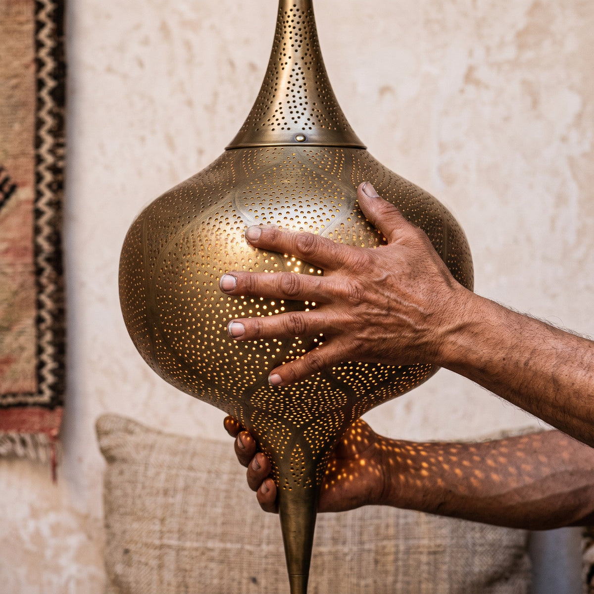 Maker's hands holding the tall Zagora lantern, unlit
