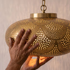 The Zohra shade held in the maker's hands in the Marrakech workshop